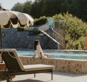 Frau auf der Terrasse mit Blick auf bewaldete Hügel im Gartenhotel Moser - 